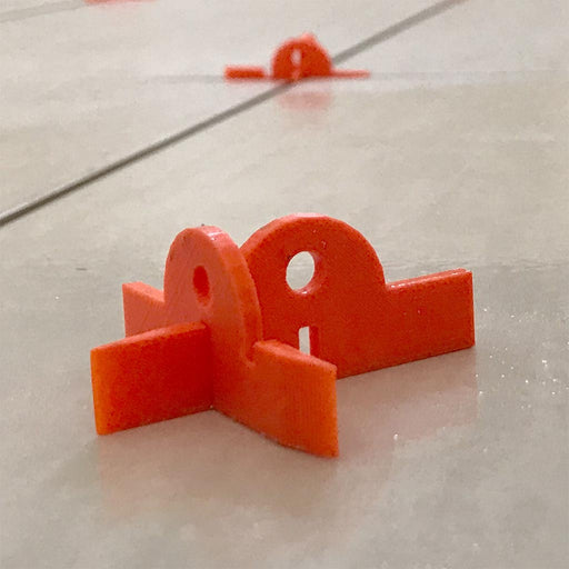 orange tile spacers on a tile floor